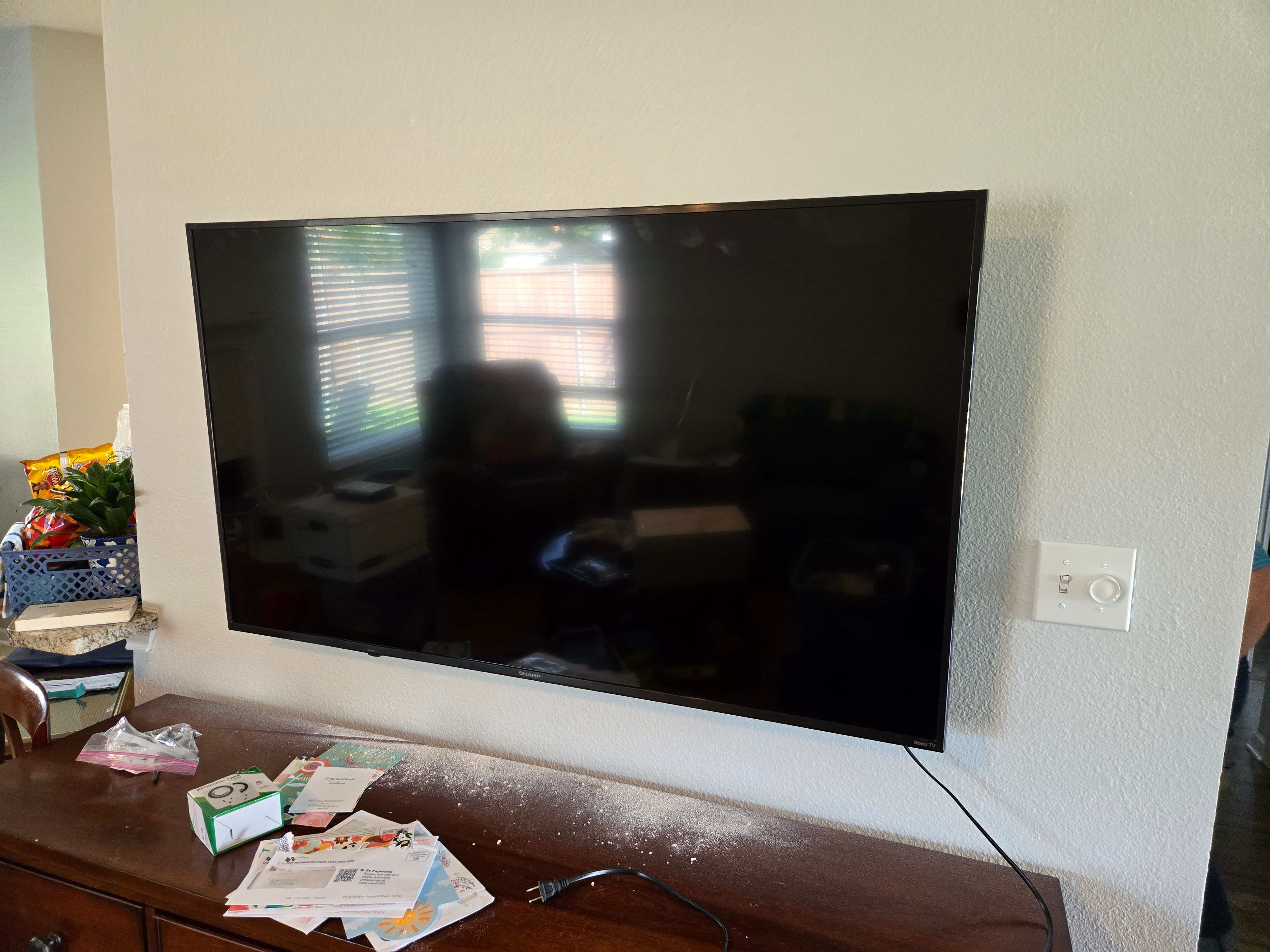 A large TV being securely mounted on a wall by Mount & Fix in Dallas
